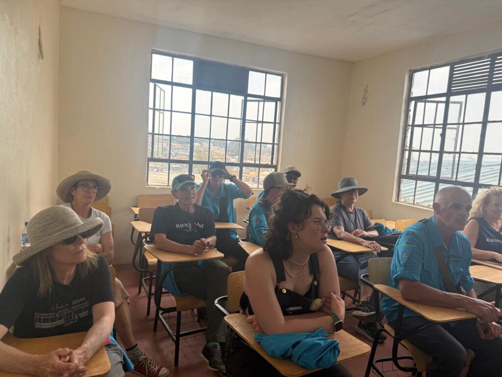 Service trip visitors seated at desks in a classroom
